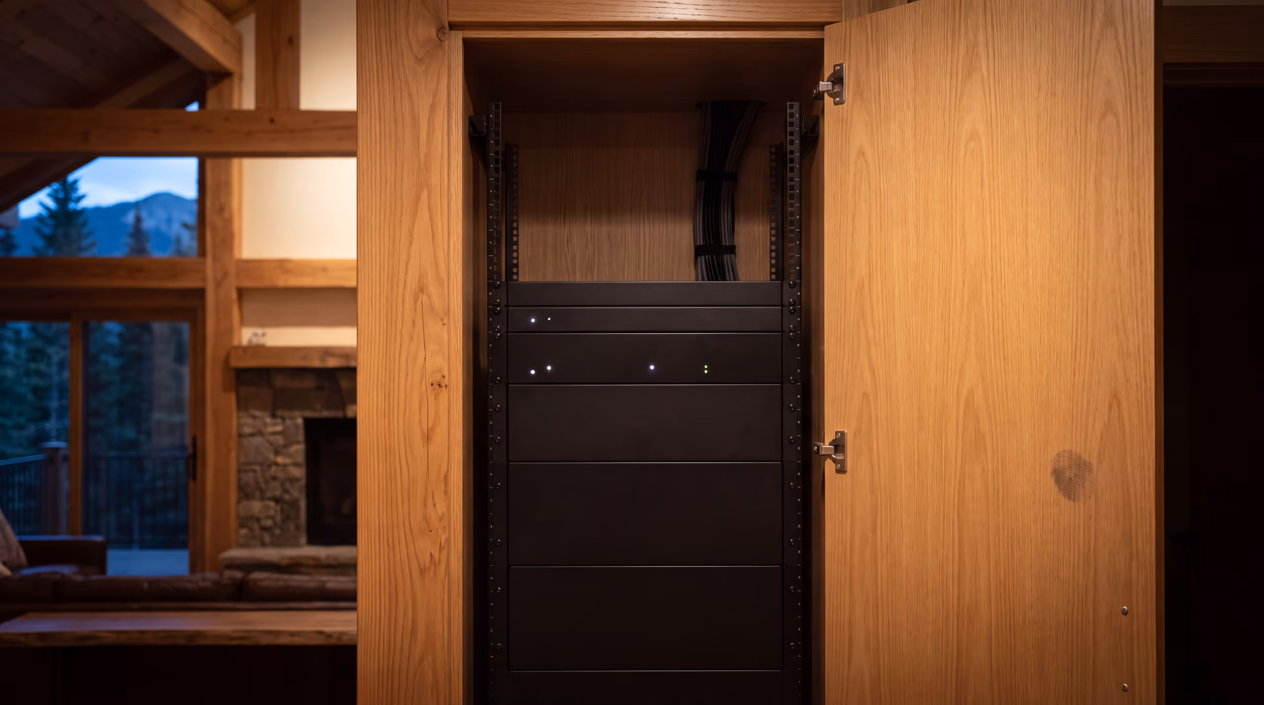 An equipment rack behind an open flush cabinet door, its front face solid and clear of cabling because every connection is made at the rear